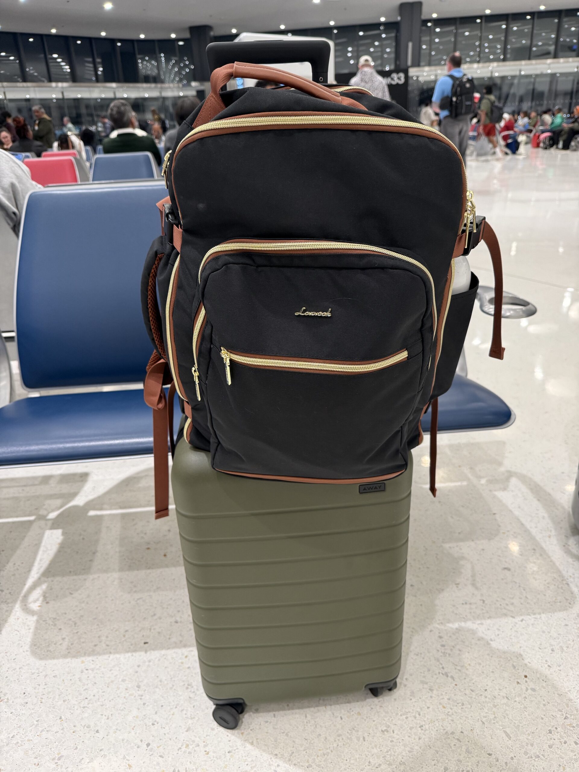 carry-on suitcase and a backpack slid over the handle, ready to travel carry-on only